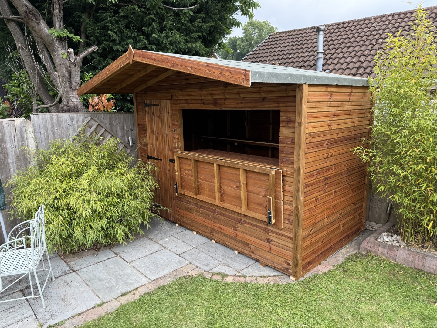 Bespoke timber shed with a large opening serving hatch