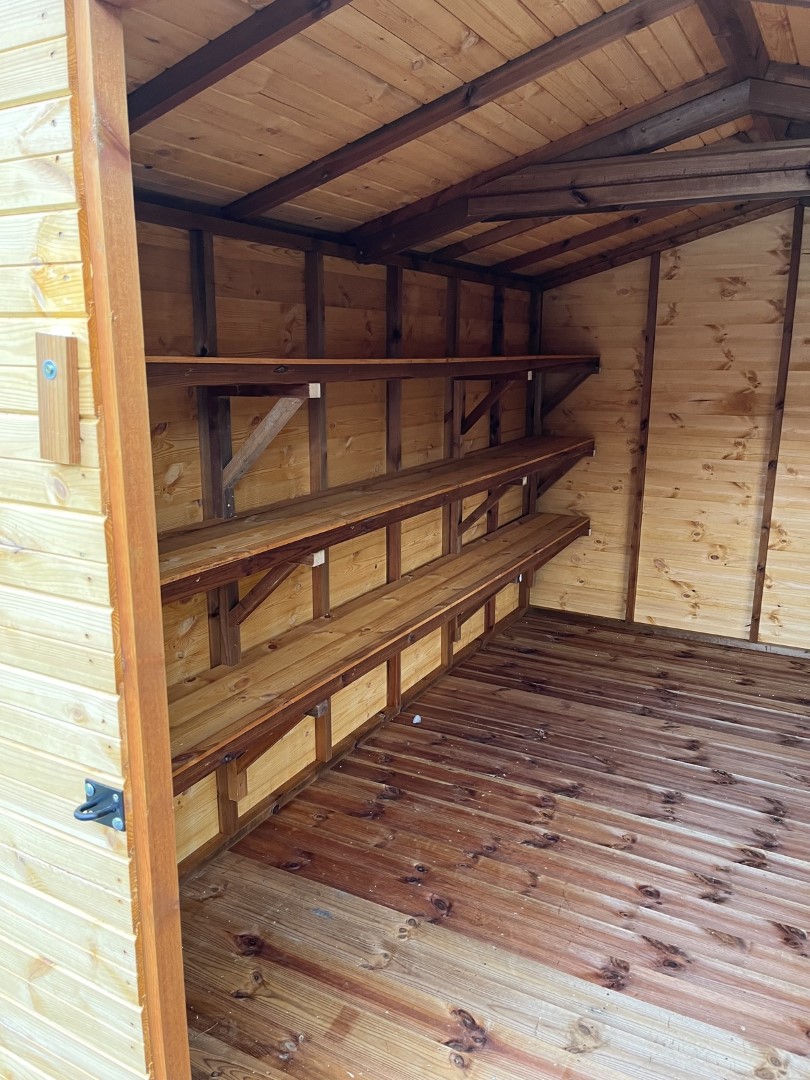 Three full-length heavy-duty shelves inside the school shed