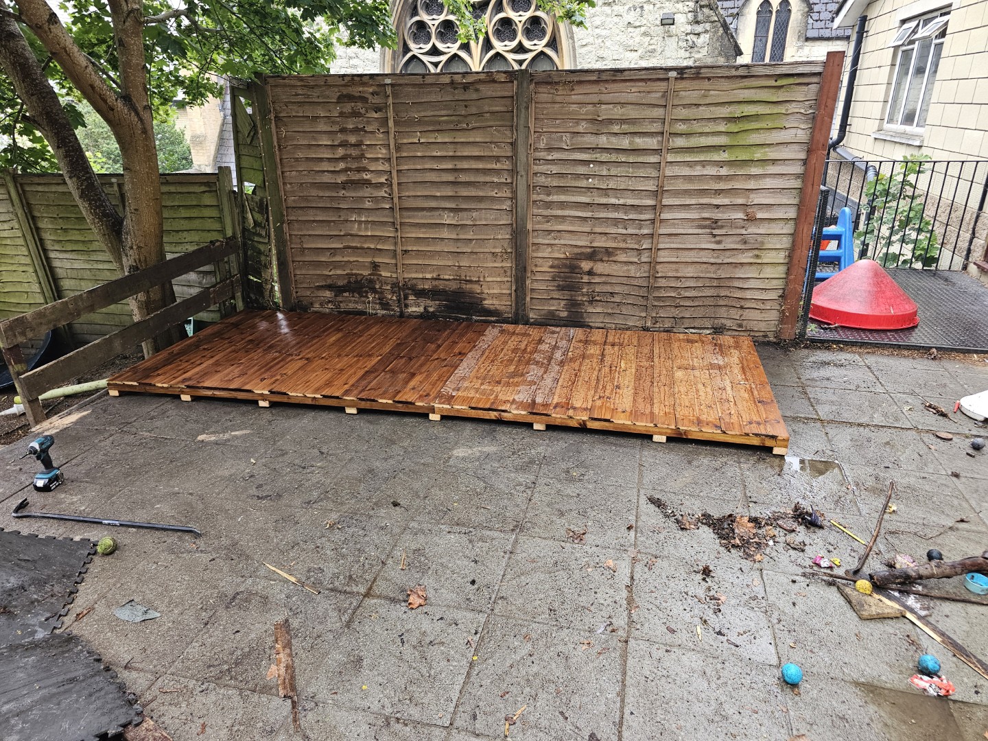 Shed floor sections being positioned on the prepared paved area before installation