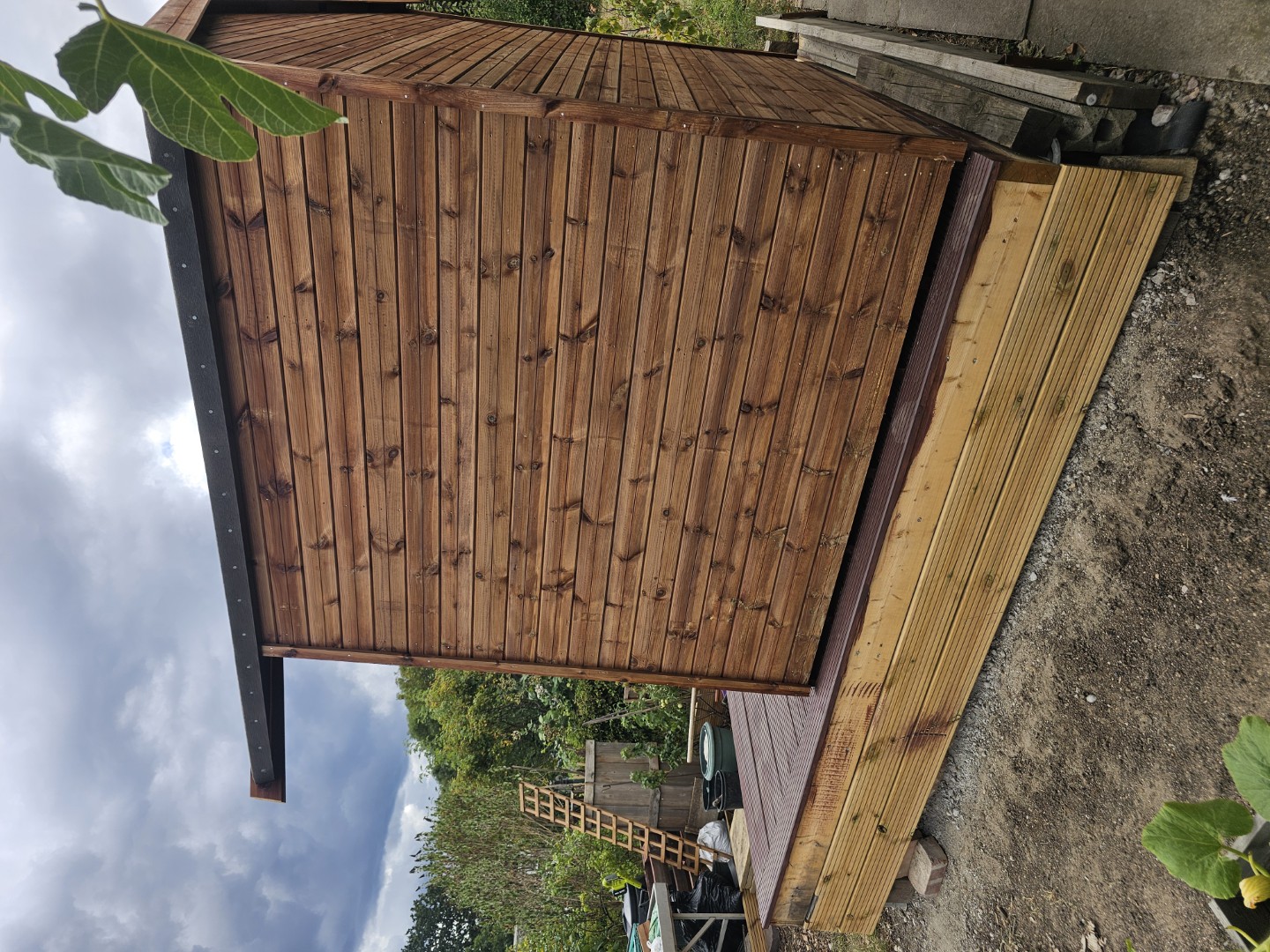 Side elevation of the timber summer house beside an allotment path